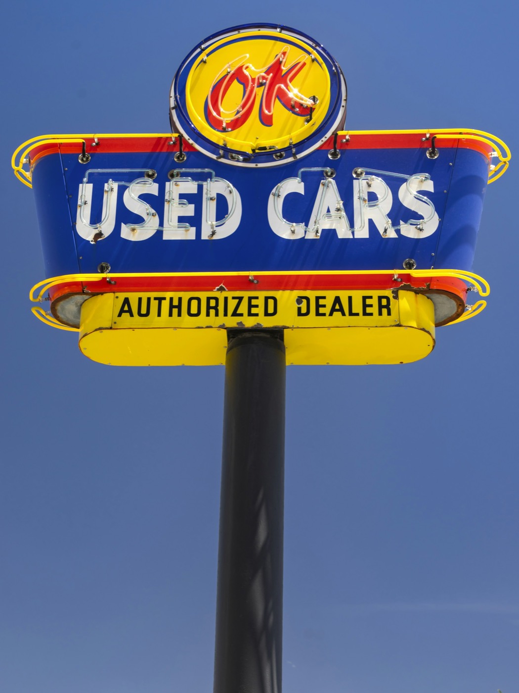 A used cars sign against a blue sky