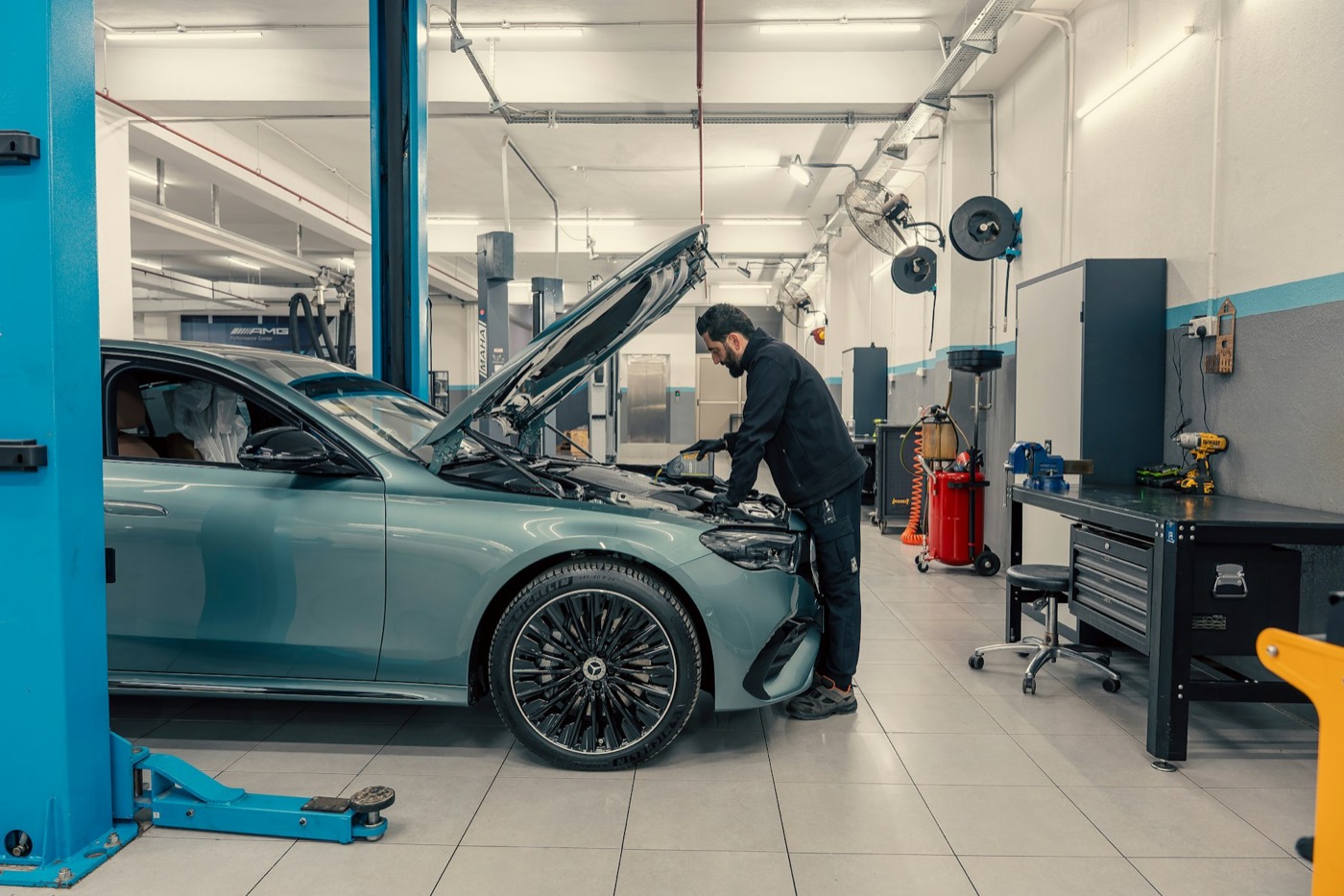 A car on a lift in a bright, tidy workshop