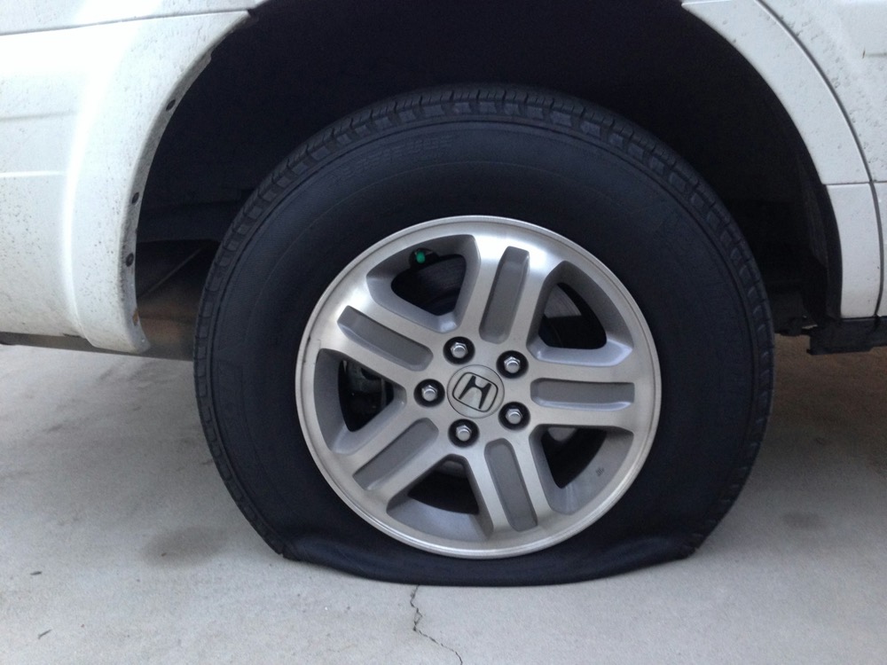 A flat tire on a white car